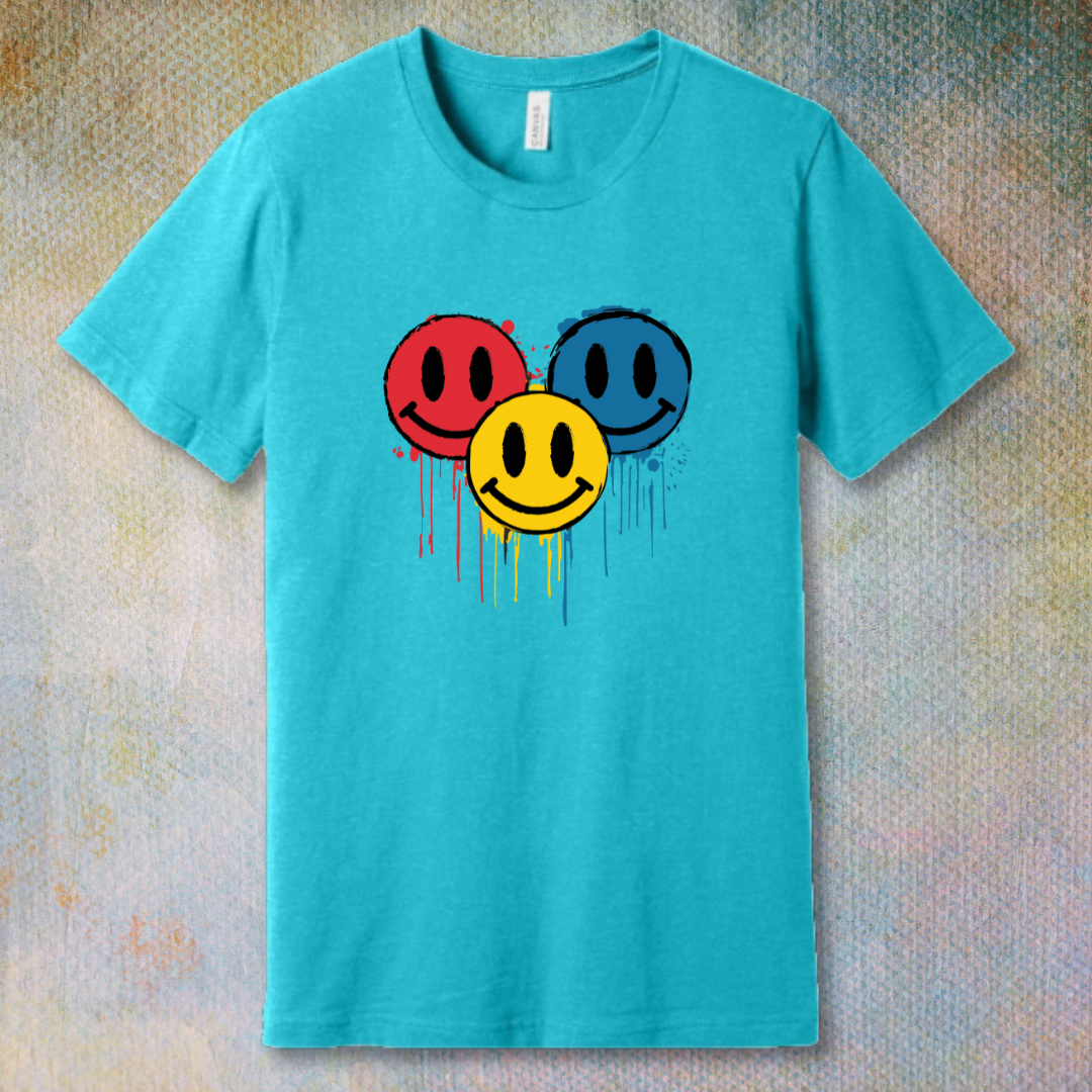 Drip Smile t-shirt — red, yellow, and blue smiley faces dripping paint on turquoise tee