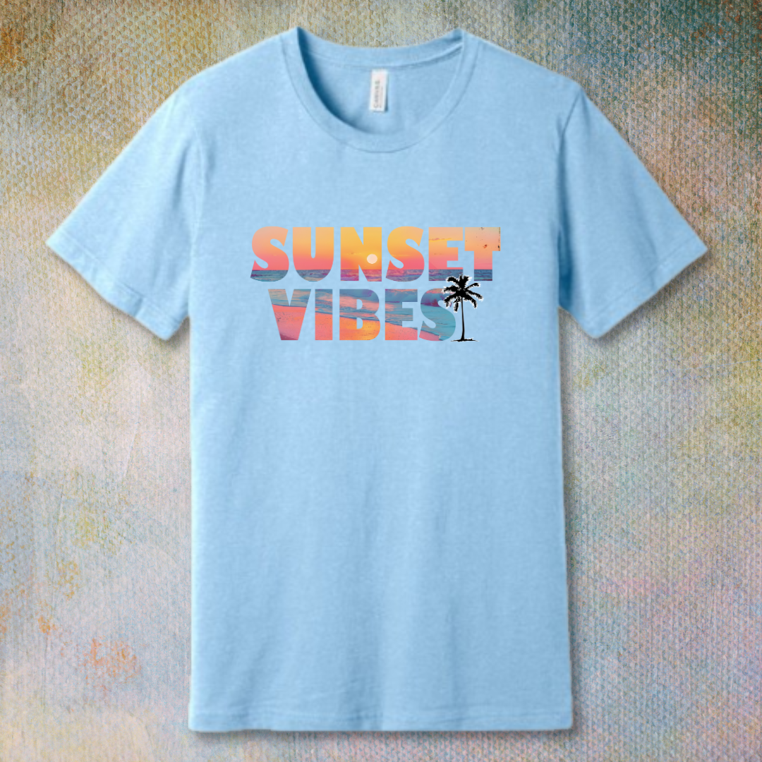 Baby Blue T-shirt with a colorful 'Sunset Vibes' design featuring a stylized sun setting over waves – soft spiritual energy and summer vibes combined.