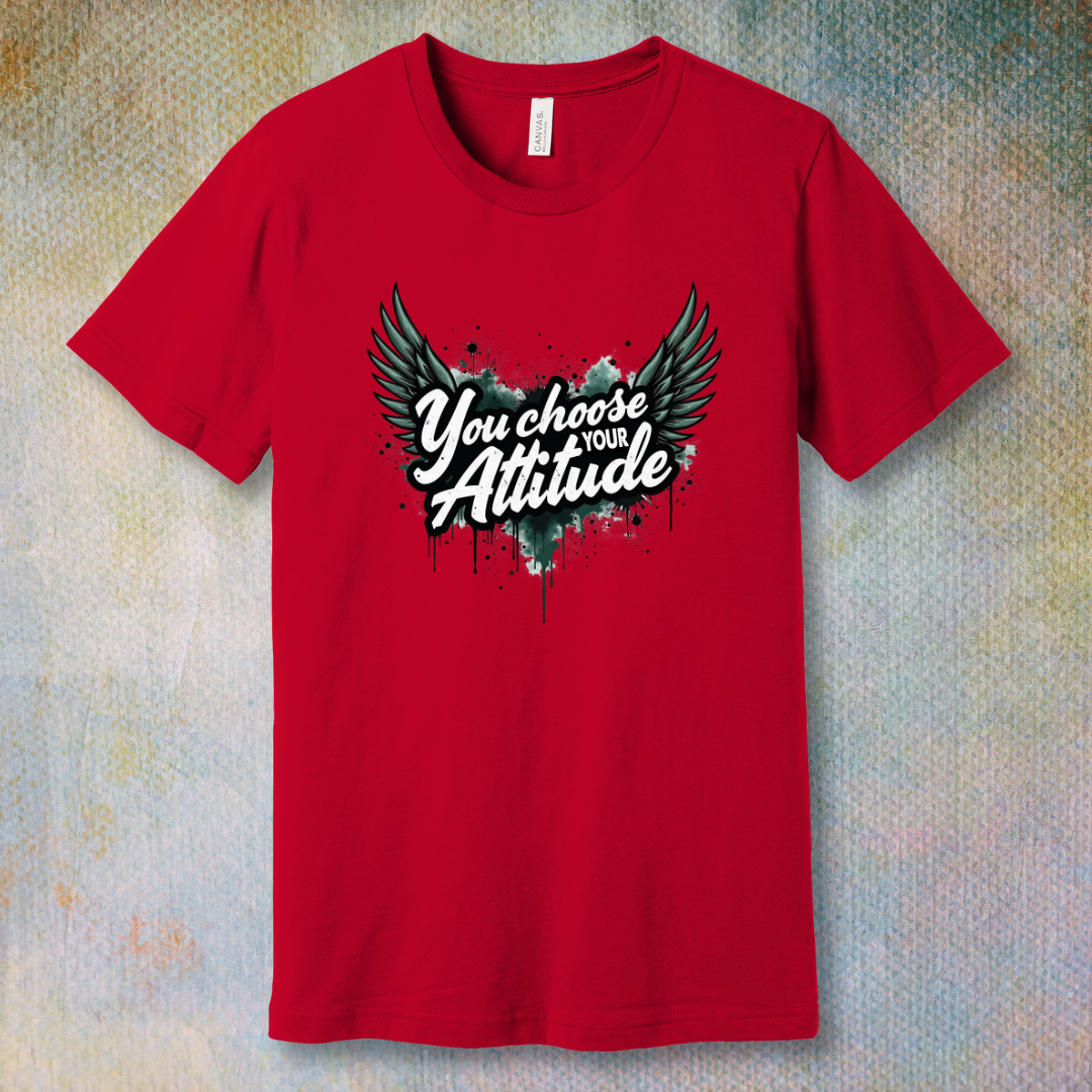 Red motivational T-shirt with “You Choose Your Attitude” text and black wings graphic over ink-splatter background