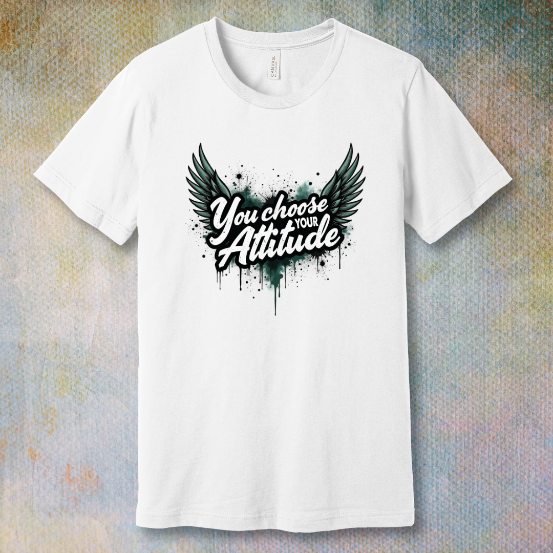White motivational T-shirt with “You Choose Your Attitude” text and black wings graphic over ink-splatter background