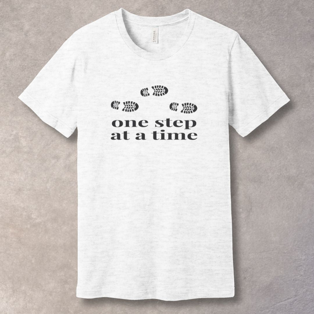 Ash t-shirt with 'one step at a time' text and footprints design
